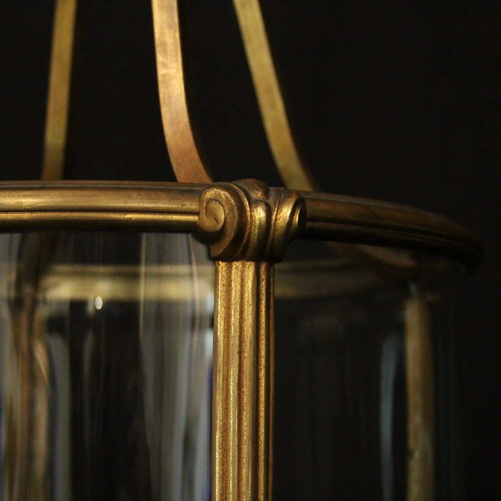A cylindrical glass and gilt bronze hanging lantern featuring four internal candle sleeves, a looped upper crown, and a suspension chain. View VIII