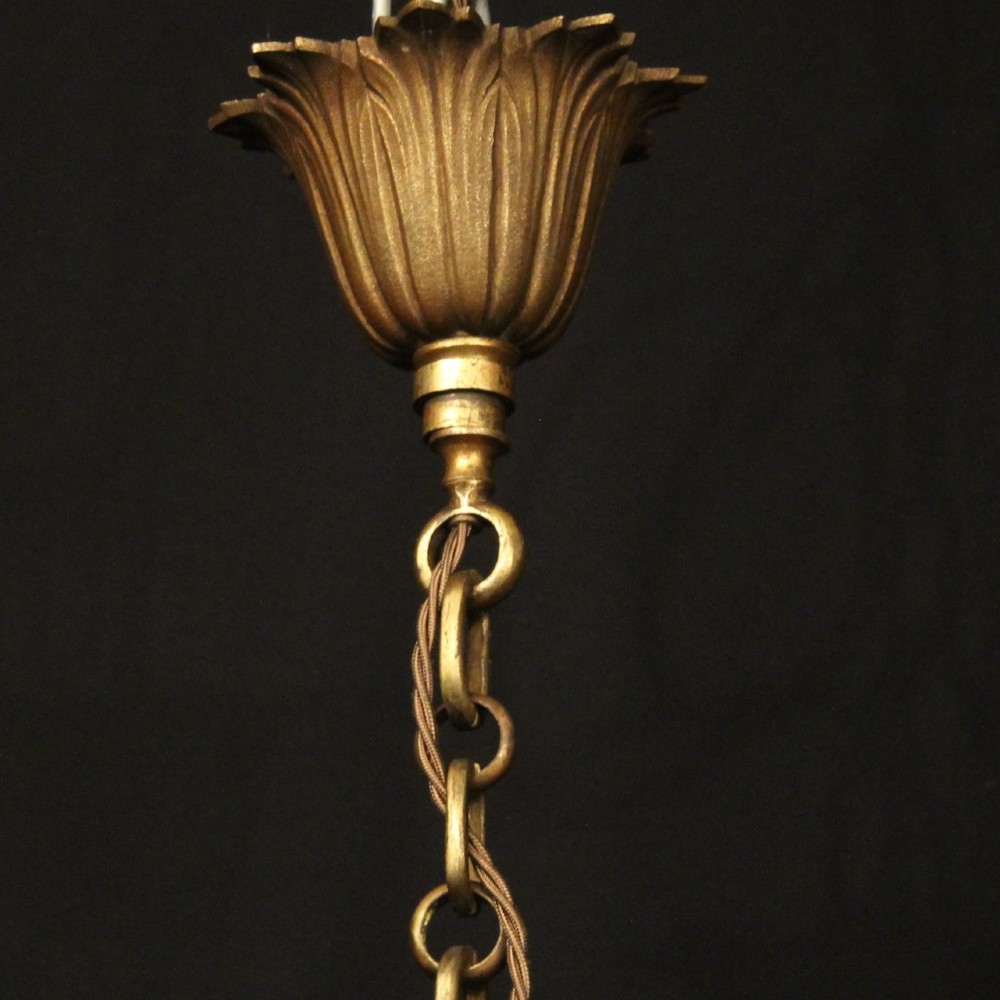 A cylindrical glass and gilt bronze hanging lantern featuring four internal candle sleeves, a looped upper crown, and a suspension chain. View X