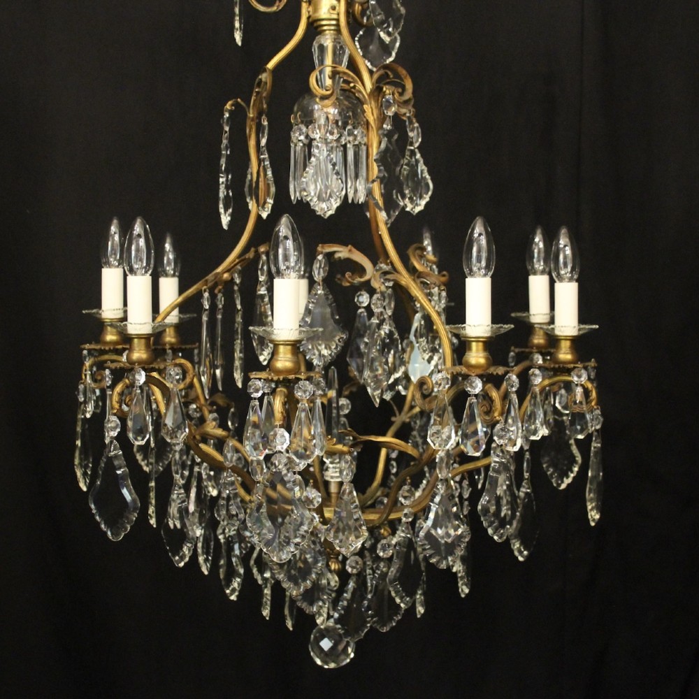 A ten-light French gilded metal chandelier featuring cascading cut-crystal glass drops and candle-style light sockets. View II