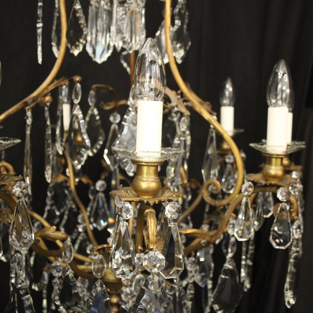 A ten-light French gilded metal chandelier featuring cascading cut-crystal glass drops and candle-style light sockets. View V