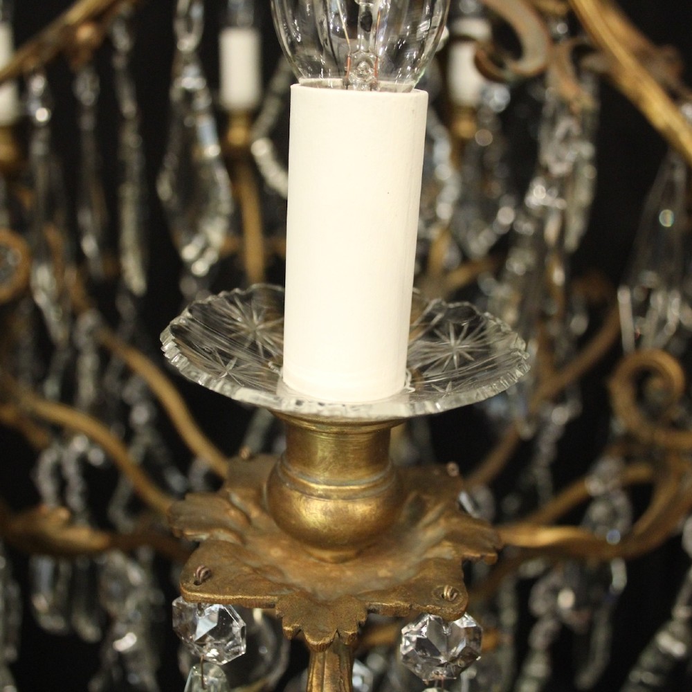 A ten-light French gilded metal chandelier featuring cascading cut-crystal glass drops and candle-style light sockets. View VI
