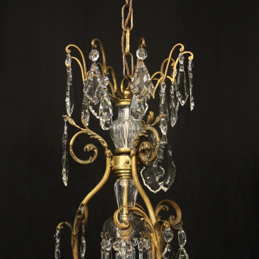A ten-light French gilded metal chandelier featuring cascading cut-crystal glass drops and candle-style light sockets. View IX
