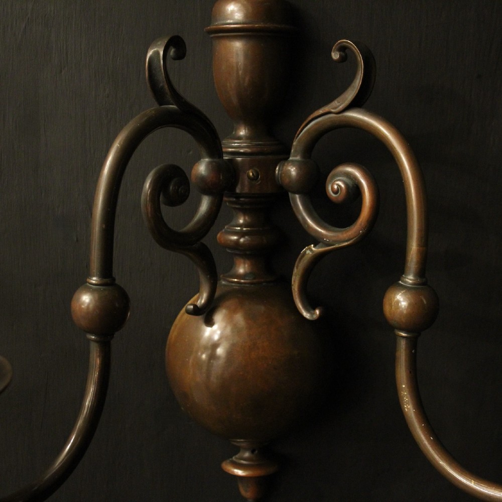 A pair of dark bronze twin-arm wall sconces featuring turned central shafts, scrollwork accents, and candle-style fittings. View VI