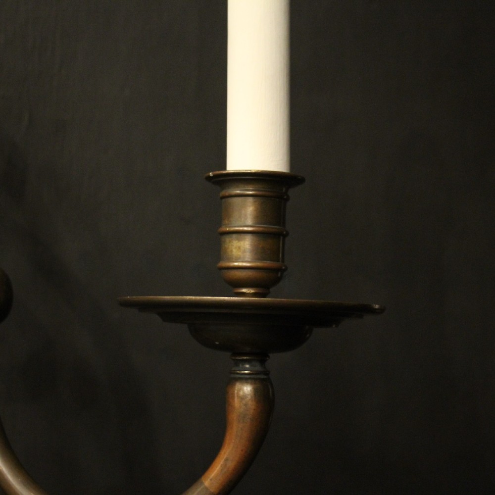 A pair of dark bronze twin-arm wall sconces featuring turned central shafts, scrollwork accents, and candle-style fittings. View VIII