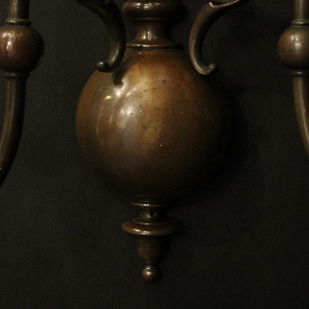 A pair of dark bronze twin-arm wall sconces featuring turned central shafts, scrollwork accents, and candle-style fittings. View IX
