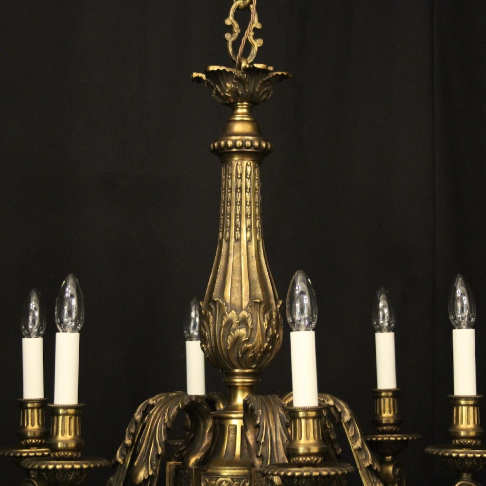 A nineteenth-century French gilded bronze chandelier with six curved arms featuring acanthus leaf motifs and white candle sleeves against a dark background. View VIII