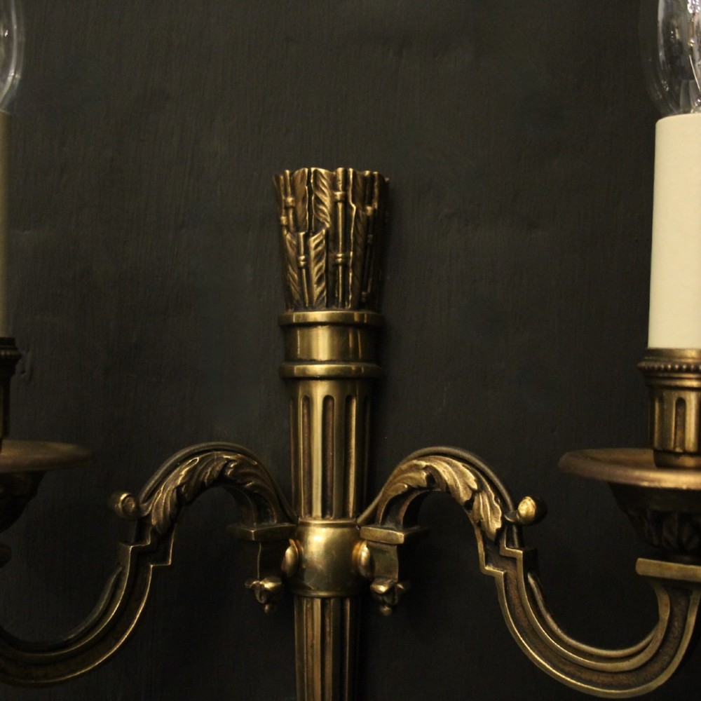 A set of four French Empire style gilded metal wall sconces, each featuring a central torch-shaped backplate and two curving candle arms. View VI