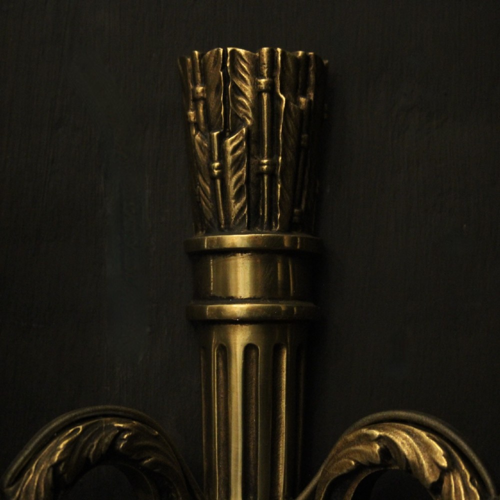 A set of four French Empire style gilded metal wall sconces, each featuring a central torch-shaped backplate and two curving candle arms. View VII