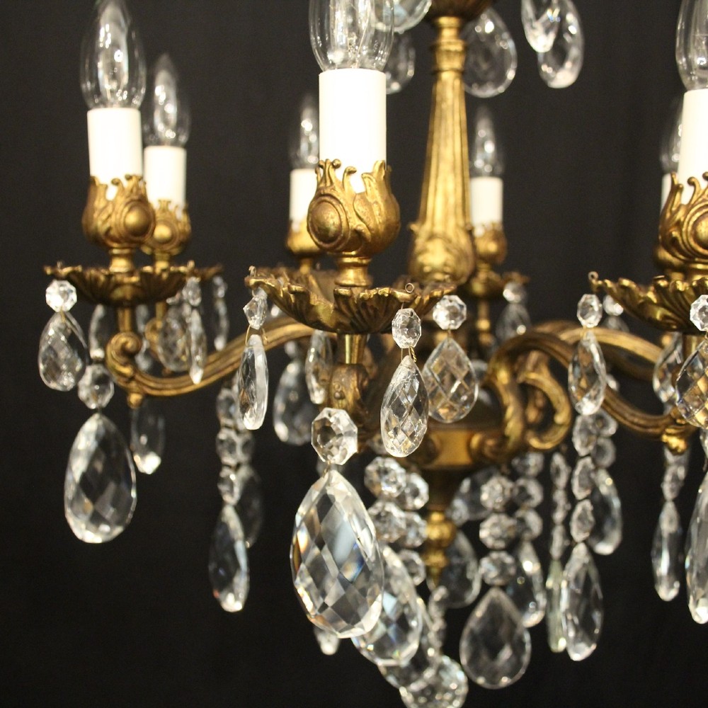 An eight-light antique French chandelier crafted from gilded metal featuring scrolling arms and clear cut glass crystal drops. View III