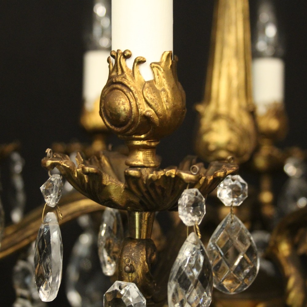 An eight-light antique French chandelier crafted from gilded metal featuring scrolling arms and clear cut glass crystal drops. View IV
