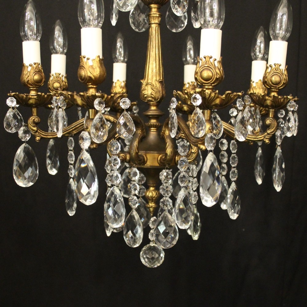 An eight-light antique French chandelier crafted from gilded metal featuring scrolling arms and clear cut glass crystal drops. View V