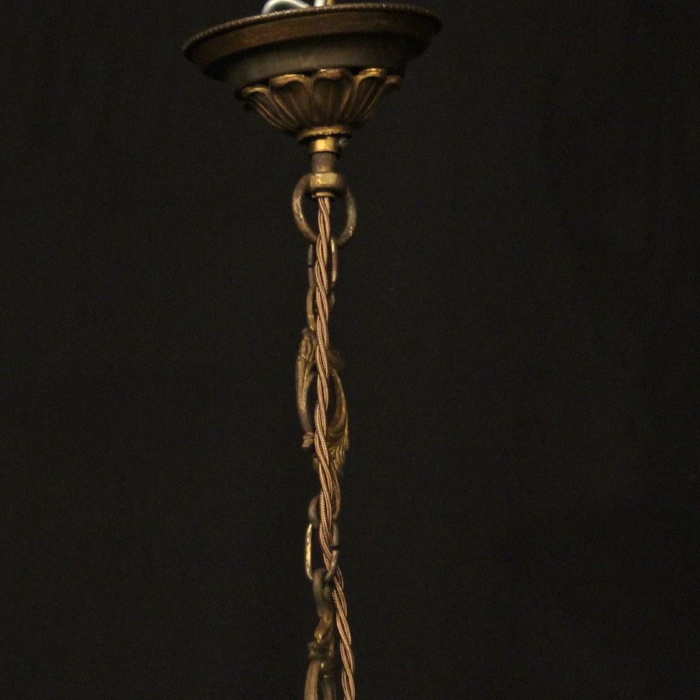 An eight-light antique French chandelier crafted from gilded metal featuring scrolling arms and clear cut glass crystal drops. View X