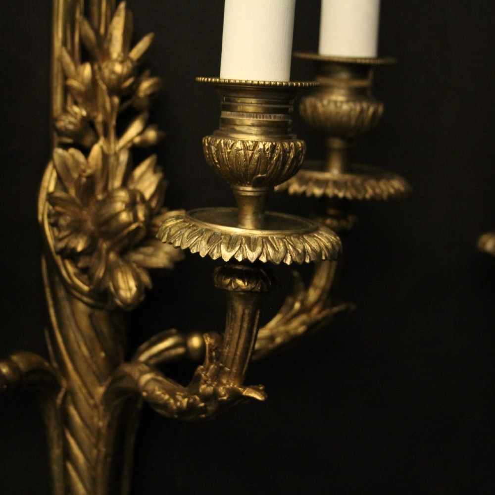 A pair of French gilt bronze three-light wall sconces featuring ribbon bow crests, tapered shafts, and scrolled candle branches. View IV