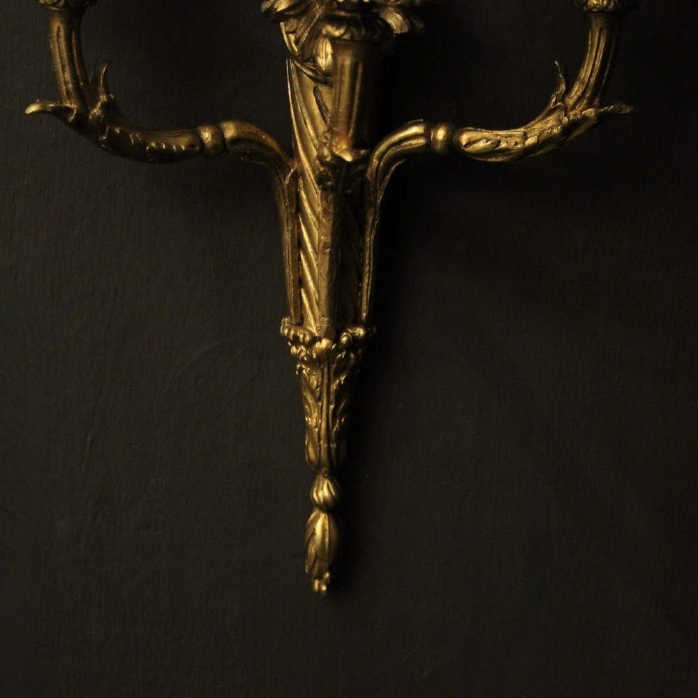 A pair of French gilt bronze three-light wall sconces featuring ribbon bow crests, tapered shafts, and scrolled candle branches. View IX