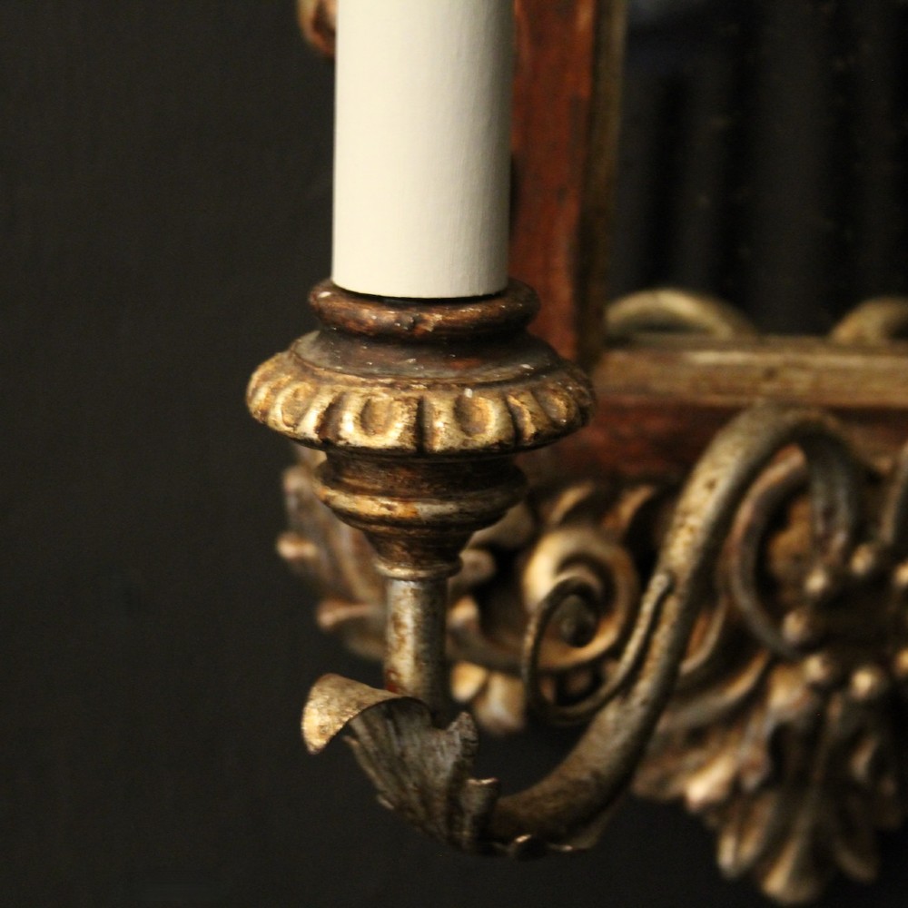 A pair of carved Florentine giltwood wall girandoles featuring arched mirror backplates, acanthus cresting, and twin light arms. View VIII