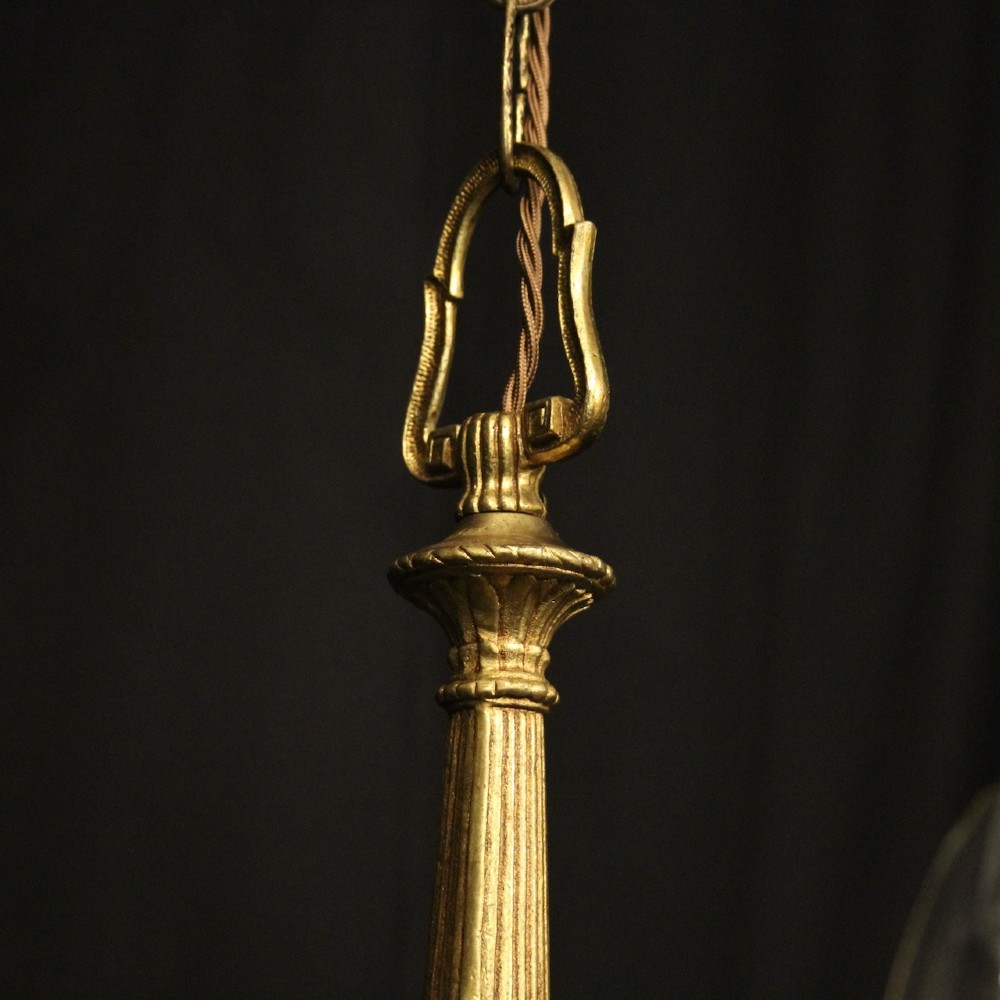 A French gilt bronze five-light chandelier featuring sweeping scroll arms, central fluted stem, decorative finial, and faux candle sleeves. View IX