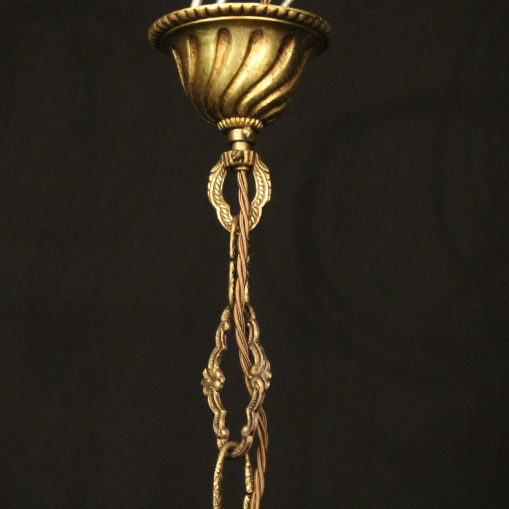 A French gilt bronze five-light chandelier featuring sweeping scroll arms, central fluted stem, decorative finial, and faux candle sleeves. View X