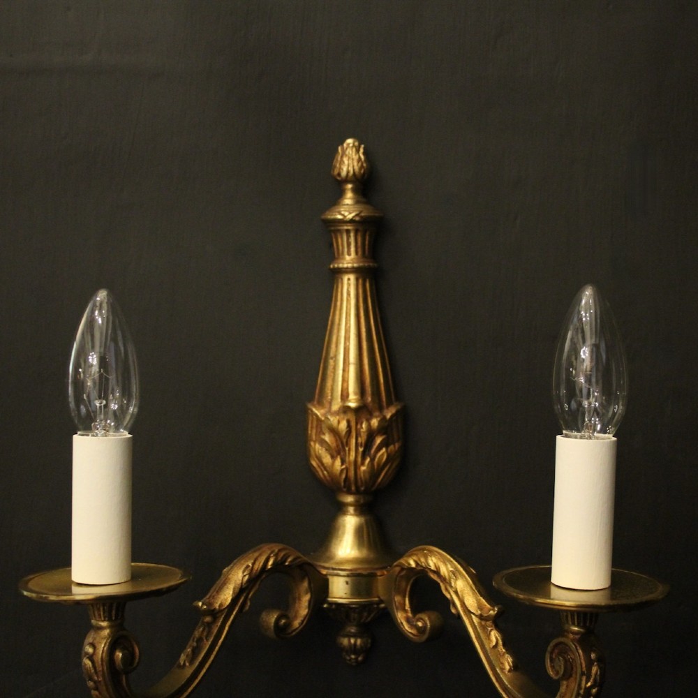 A pair of French Neoclassical gilded bronze twin-arm wall lights with acanthus leaf motifs, central fluted columns, and candle-style fittings. View III