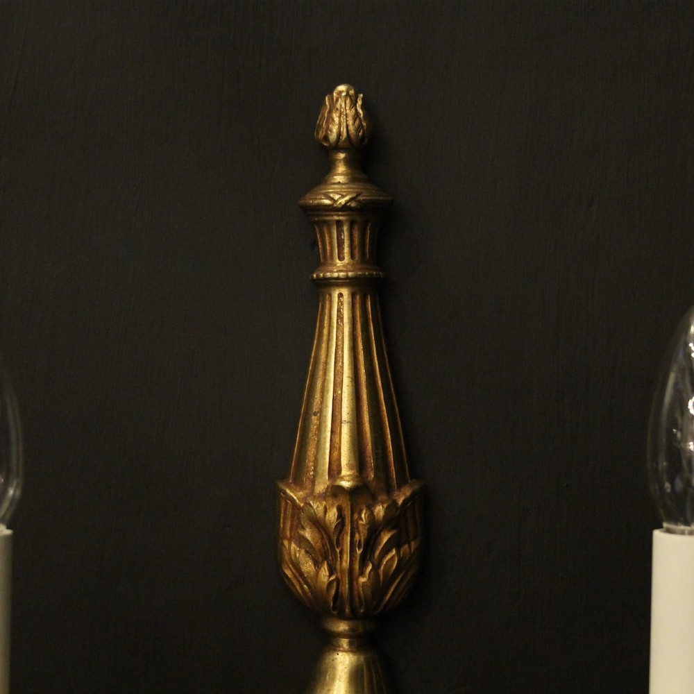 A pair of French Neoclassical gilded bronze twin-arm wall lights with acanthus leaf motifs, central fluted columns, and candle-style fittings. View IV