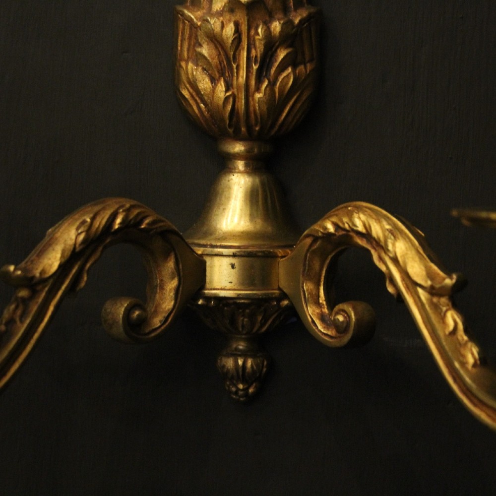A pair of French Neoclassical gilded bronze twin-arm wall lights with acanthus leaf motifs, central fluted columns, and candle-style fittings. View IX