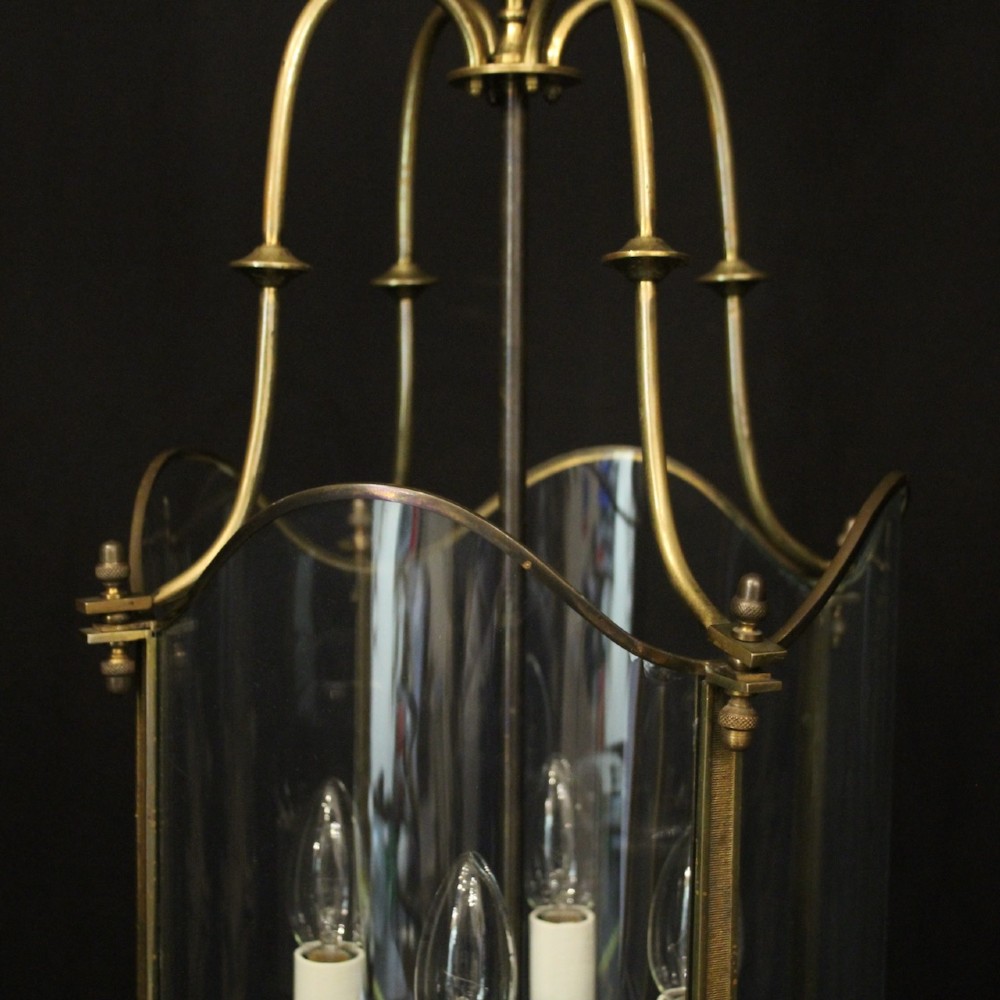 A hanging gilt brass hall lantern featuring curved convex glass panels and an internal four-candle light cluster supported by a central chain. View IV