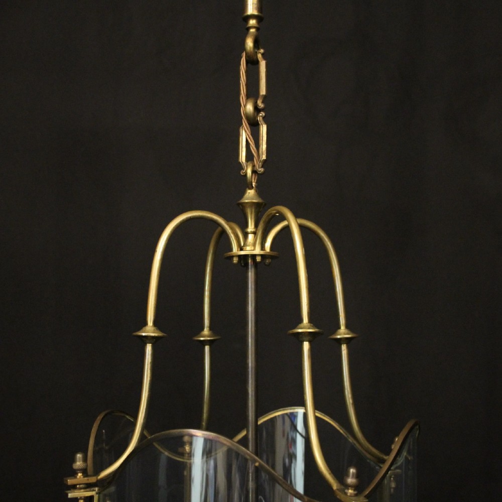A hanging gilt brass hall lantern featuring curved convex glass panels and an internal four-candle light cluster supported by a central chain. View VI