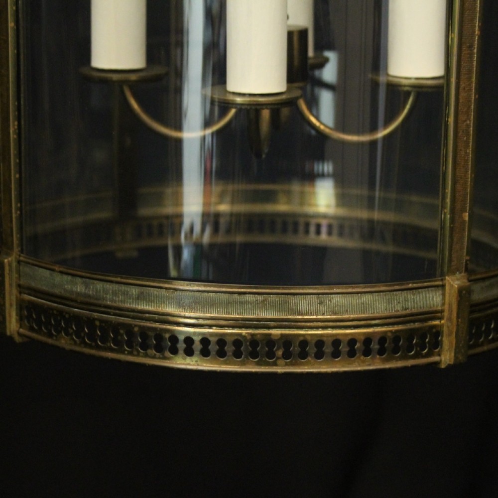 A hanging gilt brass hall lantern featuring curved convex glass panels and an internal four-candle light cluster supported by a central chain. View IX