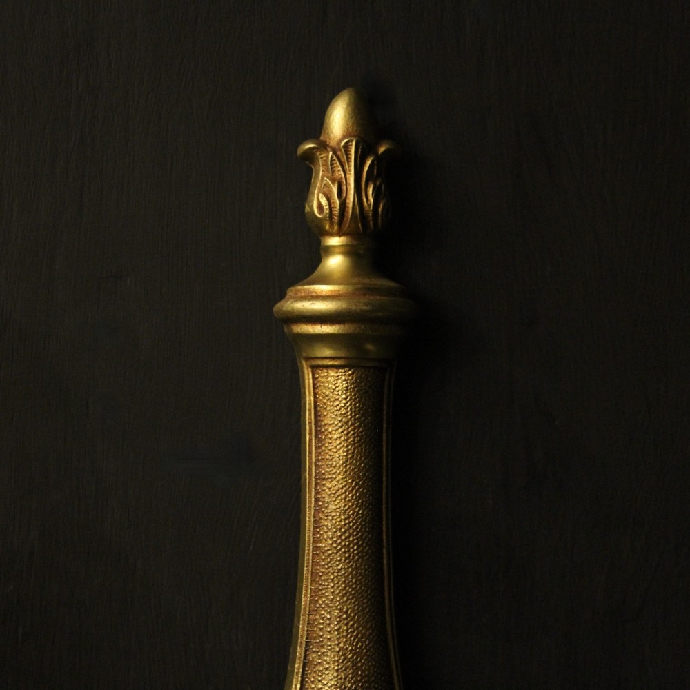 A set of four French gilded brass twin-arm wall sconces featuring scrolled arms, leaf motifs, and flame finials. View VI