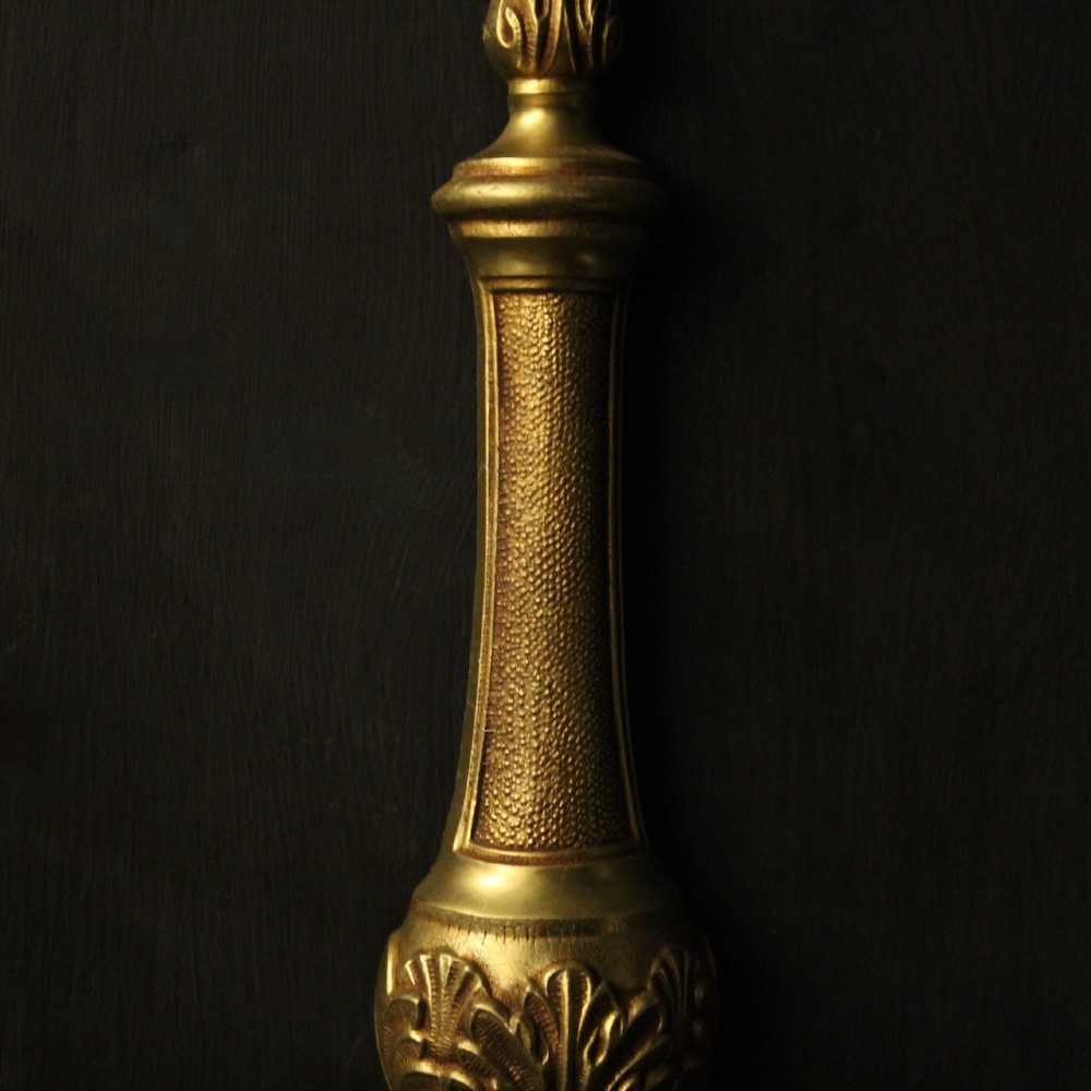 A set of four French gilded brass twin-arm wall sconces featuring scrolled arms, leaf motifs, and flame finials. View VII