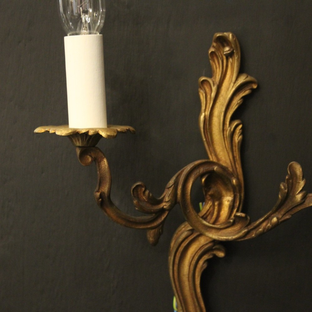 A set of four antique French twin-arm wall sconces crafted from gilded metal featuring ornate acanthus leaf scrolls. View III