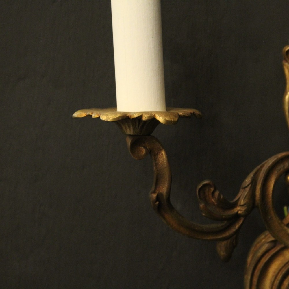 A set of four antique French twin-arm wall sconces crafted from gilded metal featuring ornate acanthus leaf scrolls. View VII