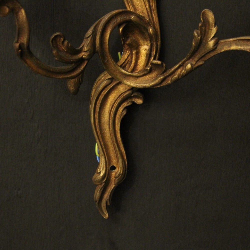 A set of four antique French twin-arm wall sconces crafted from gilded metal featuring ornate acanthus leaf scrolls. View IX