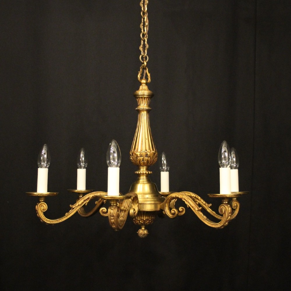 A French six-light chandelier constructed from gilded bronze featuring a fluted central column and scroll-form acanthus arms.