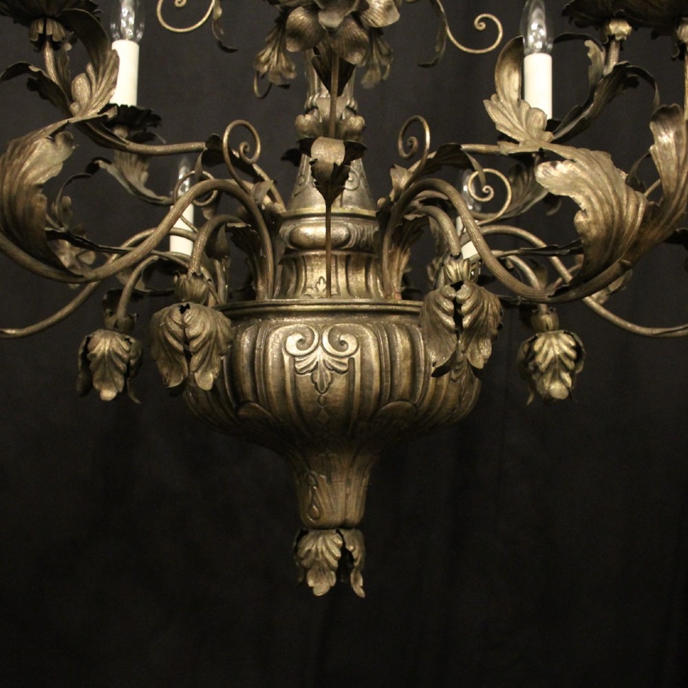 An antique Italian Genoa twelve-light chandelier crafted from gilded metal featuring ornate leaf motifs and scrolling arms supporting candle bulb holders. View VIII