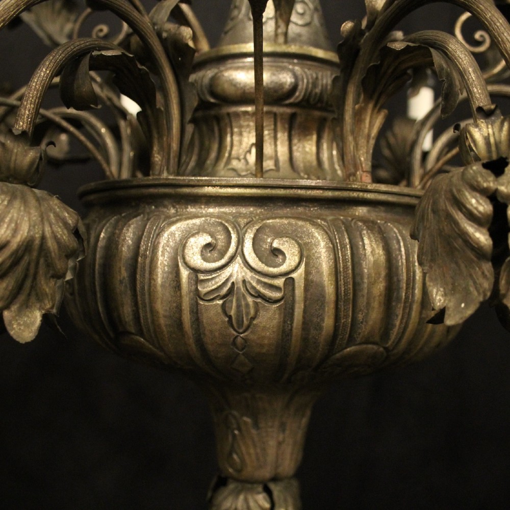 An antique Italian Genoa twelve-light chandelier crafted from gilded metal featuring ornate leaf motifs and scrolling arms supporting candle bulb holders. View IX
