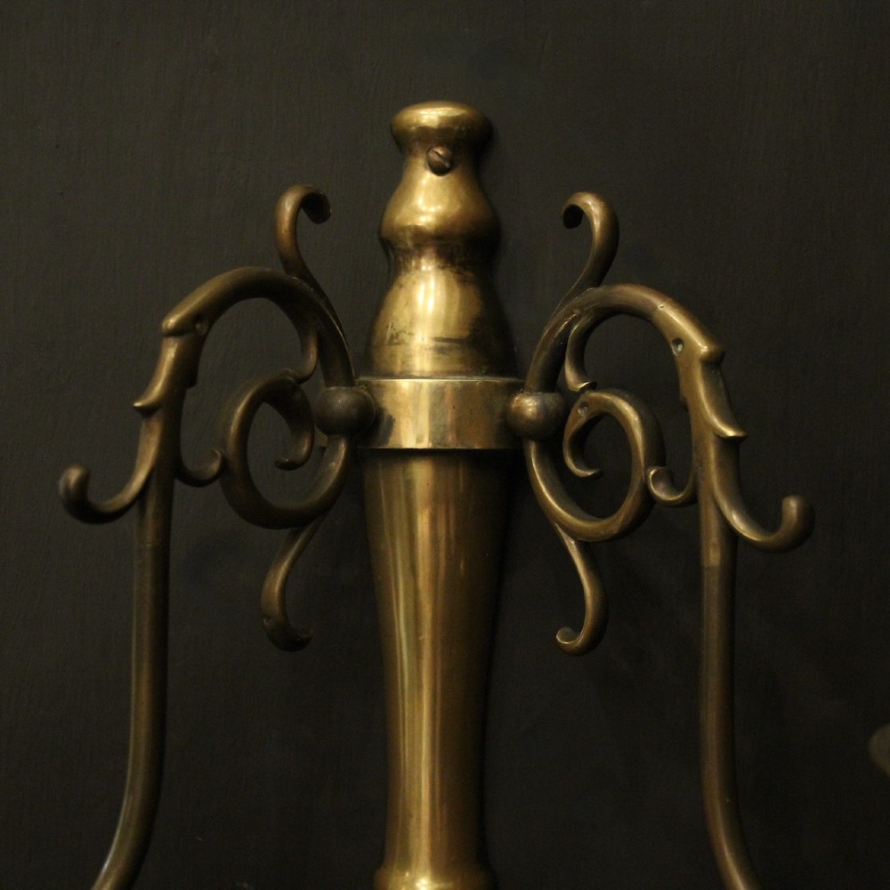 A set of four matching antique brass twin-arm wall sconces featuring curved scrollwork and candle-style bulb sockets. View IV