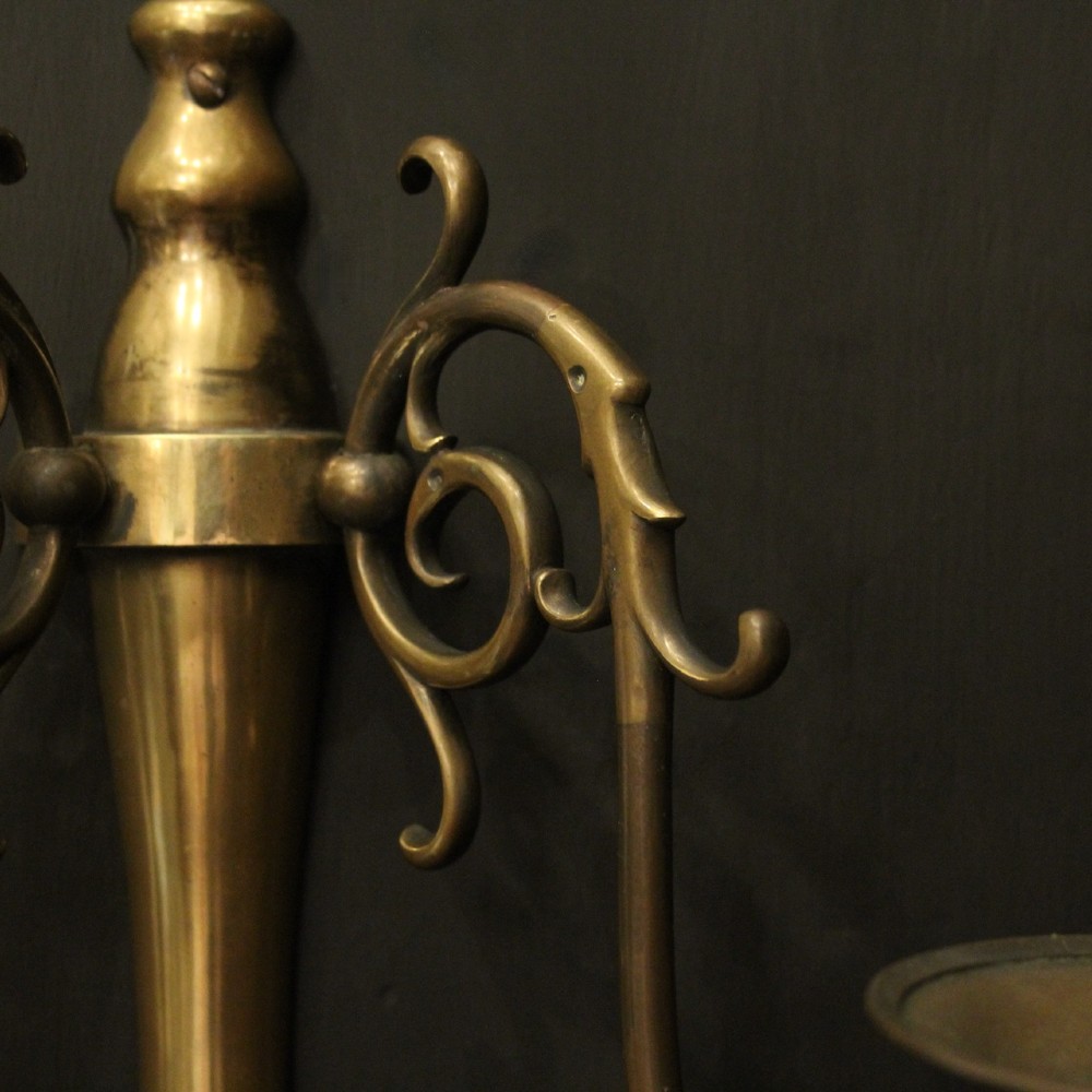 A set of four matching antique brass twin-arm wall sconces featuring curved scrollwork and candle-style bulb sockets. View IX