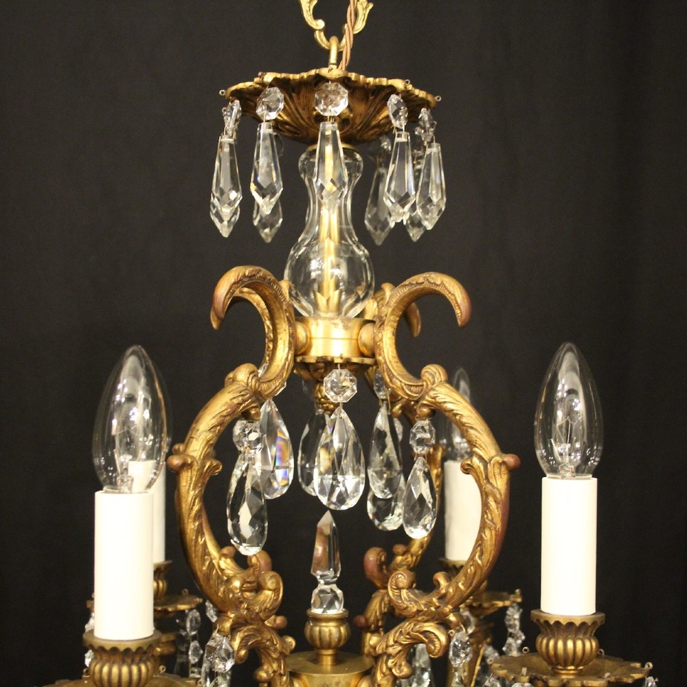 An antique French four-light chandelier featuring a scrollwork gilt bronze frame hung with faceted crystal drops. View VII