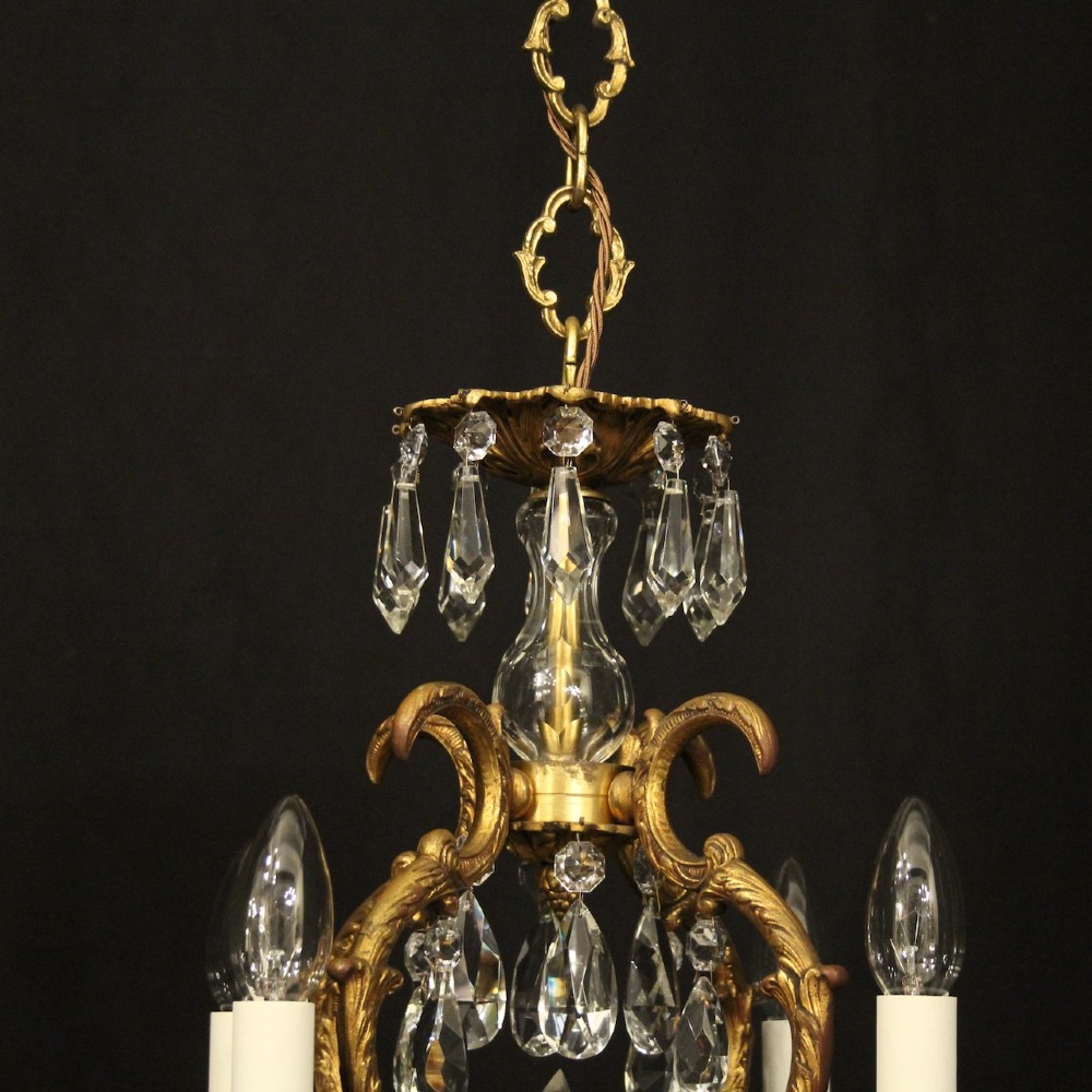 An antique French four-light chandelier featuring a scrollwork gilt bronze frame hung with faceted crystal drops. View VIII