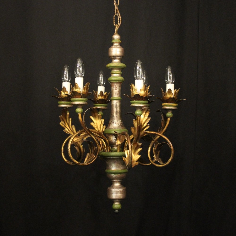 A Florentine six-arm giltwood chandelier featuring hand-carved acanthus leaves, turned central column, green painted accents, and distressed gold leaf finish.