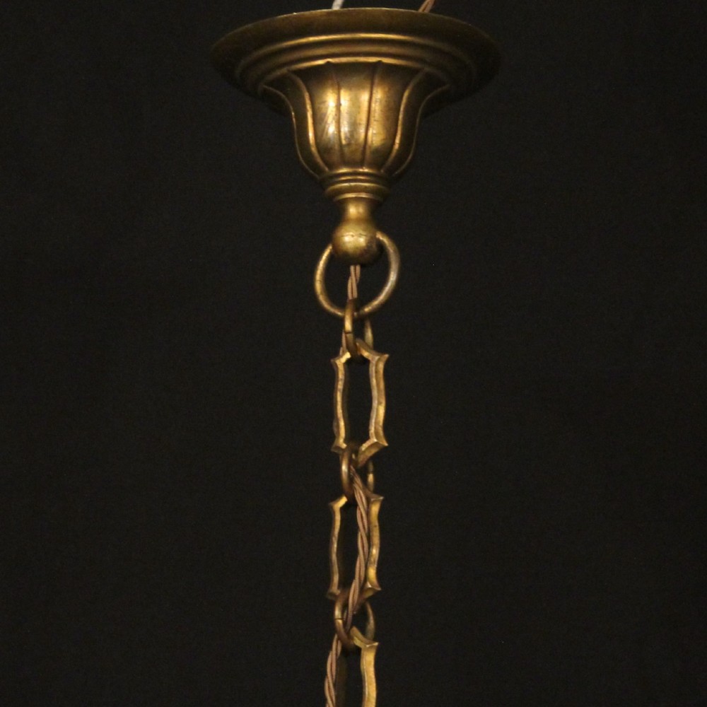 An antique French gilded bronze hall lantern featuring convex glass panels surrounding a four-light candle-style fixture with ornate scrollwork top brackets. View X