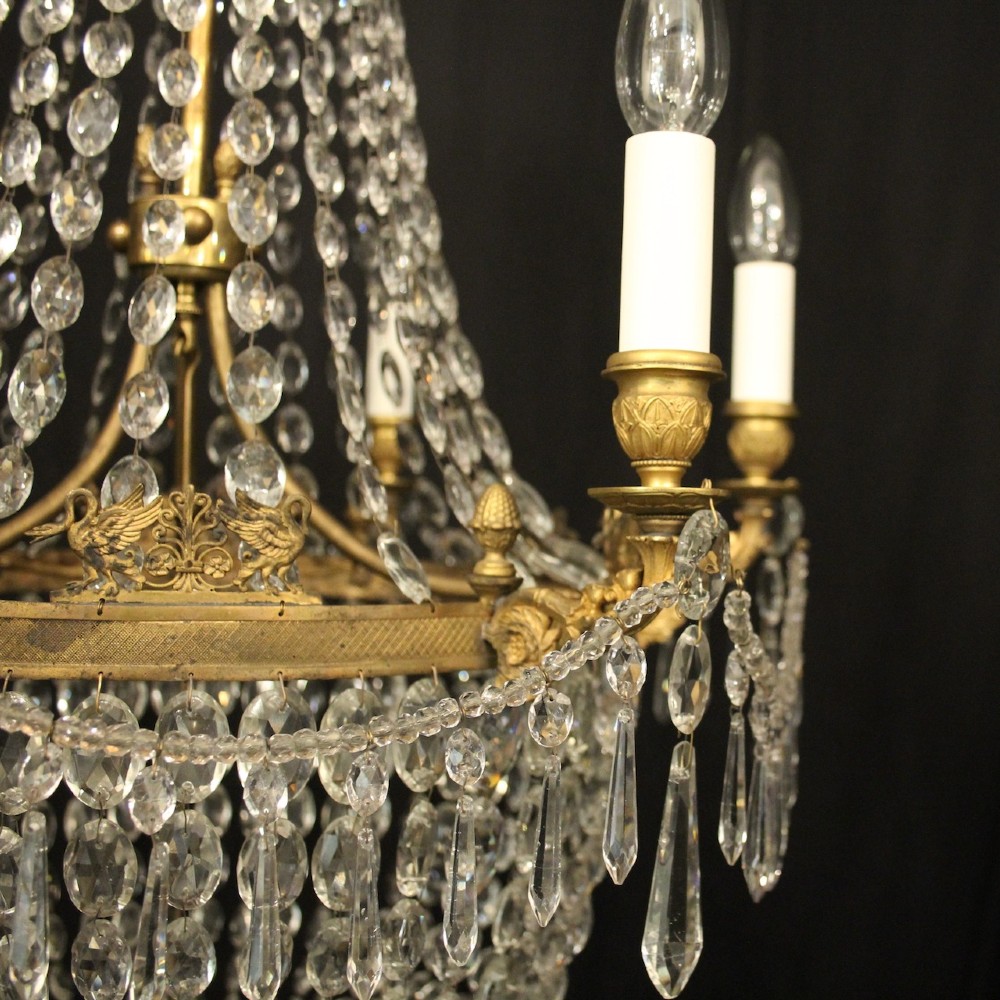 A 19th-century French gilt bronze tent and waterfall chandelier adorned with cascading crystal beads, candle sockets, and hanging glass prisms. View VI