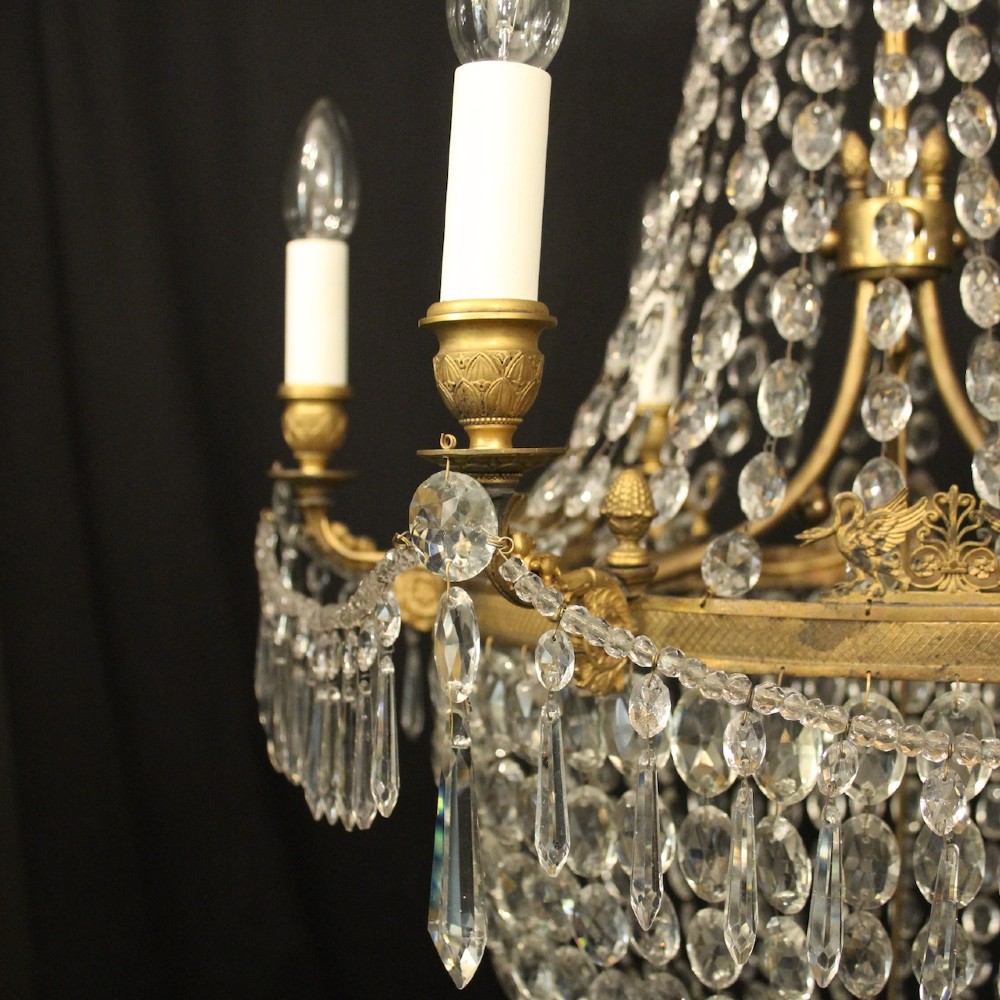 A 19th-century French gilt bronze tent and waterfall chandelier adorned with cascading crystal beads, candle sockets, and hanging glass prisms. View VII