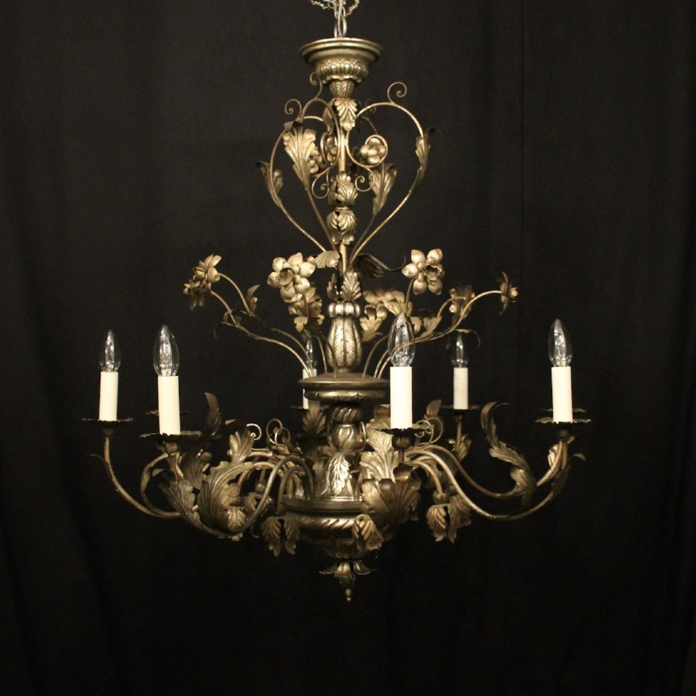 An eight-light Italian silvered gilded metal chandelier featuring elaborate foliate leaves, floral flourishes, and candle-style sockets.