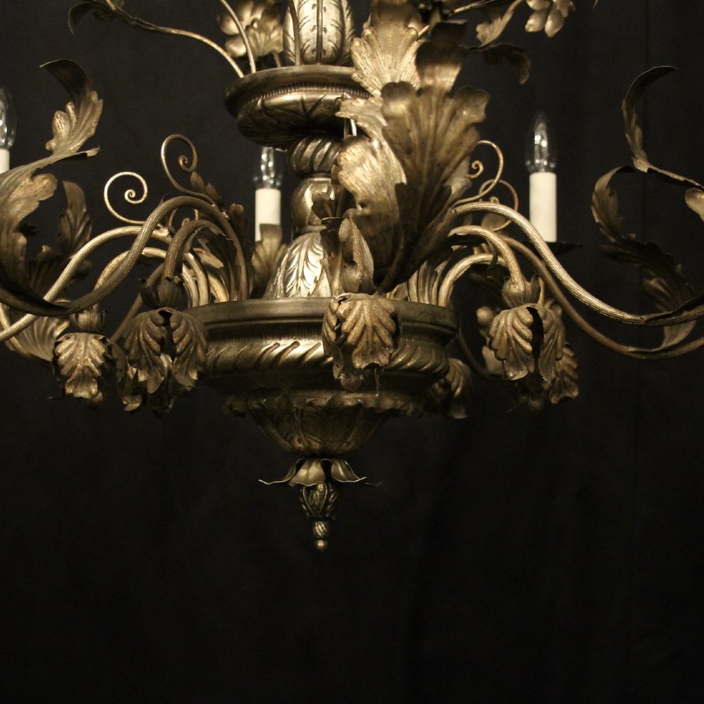 An eight-light Italian silvered gilded metal chandelier featuring elaborate foliate leaves, floral flourishes, and candle-style sockets. View VII