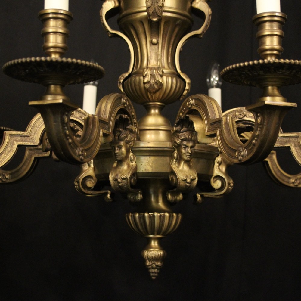 An eight-arm French gilt bronze chandelier featuring an urn-shaped central stem, cast classical busts, and candle-style bulb holders. View VIII