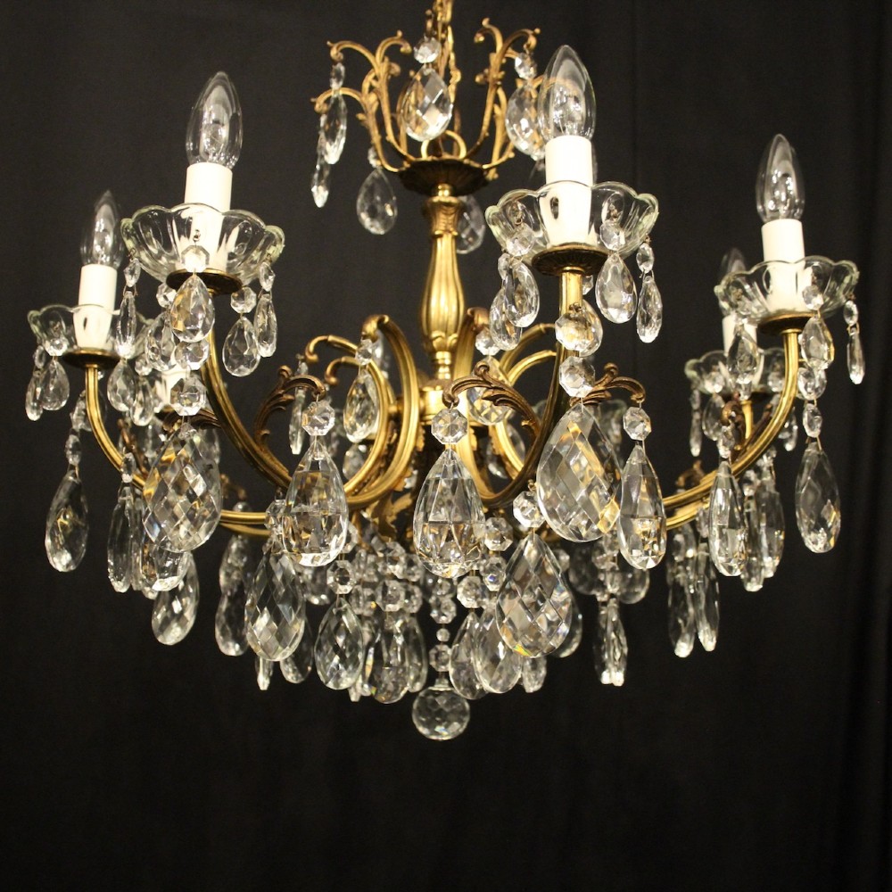 An eight-light French gilded brass chandelier featuring decorative scroll arms and hanging faceted crystal drops. View II