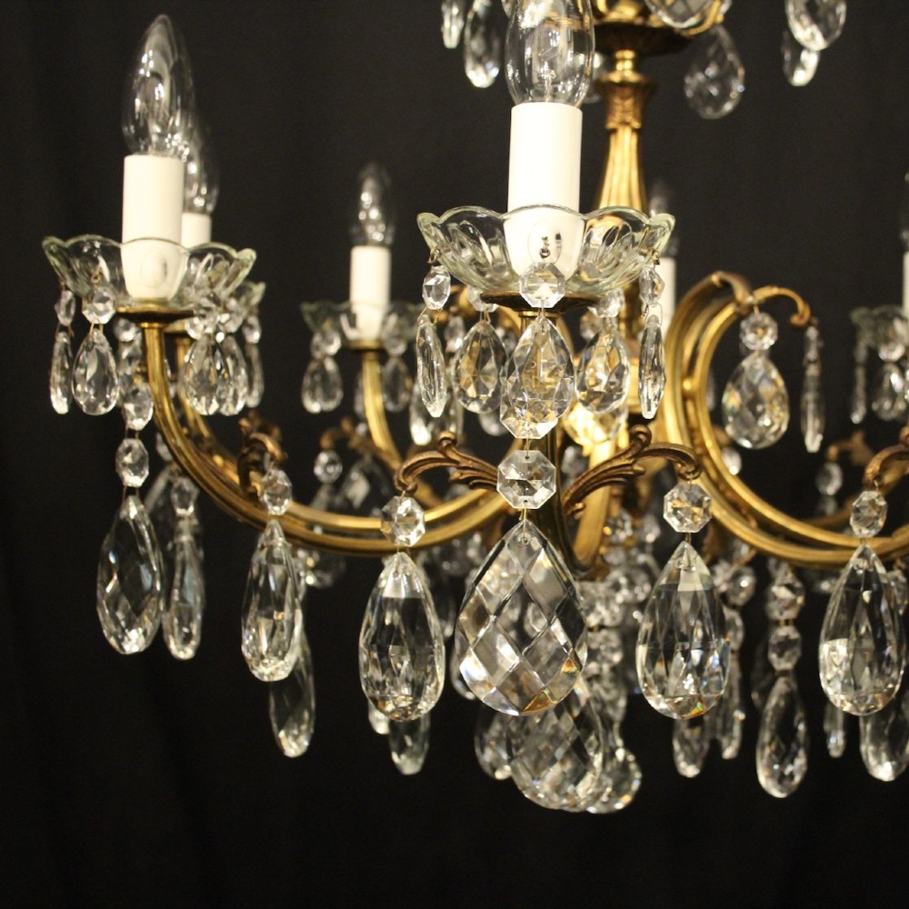 An eight-light French gilded brass chandelier featuring decorative scroll arms and hanging faceted crystal drops. View III