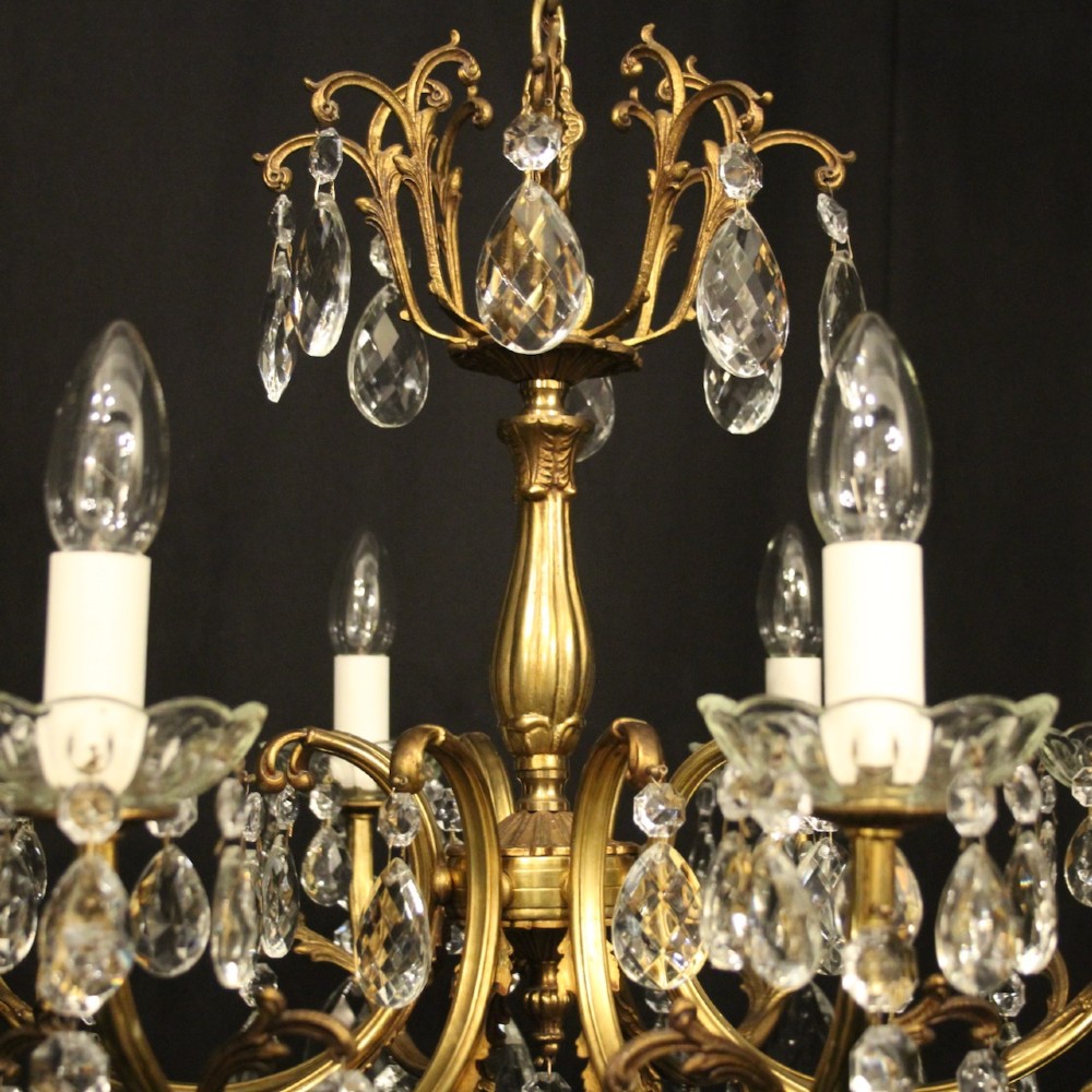 An eight-light French gilded brass chandelier featuring decorative scroll arms and hanging faceted crystal drops. View VIII