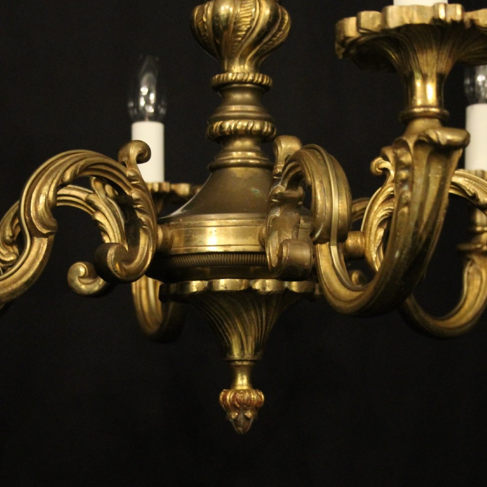 A six-arm French gilt bronze chandelier featuring scrolled arms, leaf motifs, and faux candle bulb holders hanging from a central column. View VII